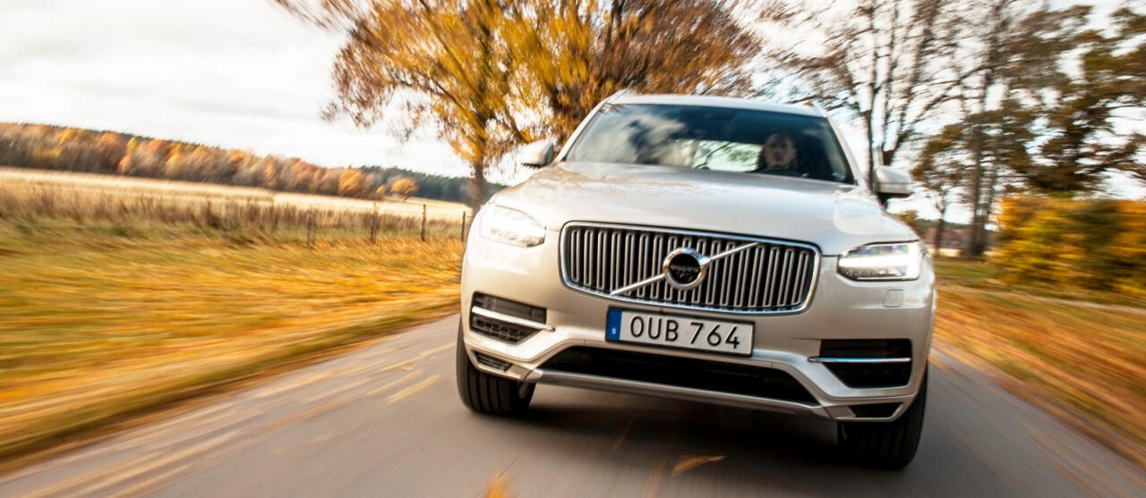 En Volvo XC90-terrängbil kör längs en landsväg. (AI text)