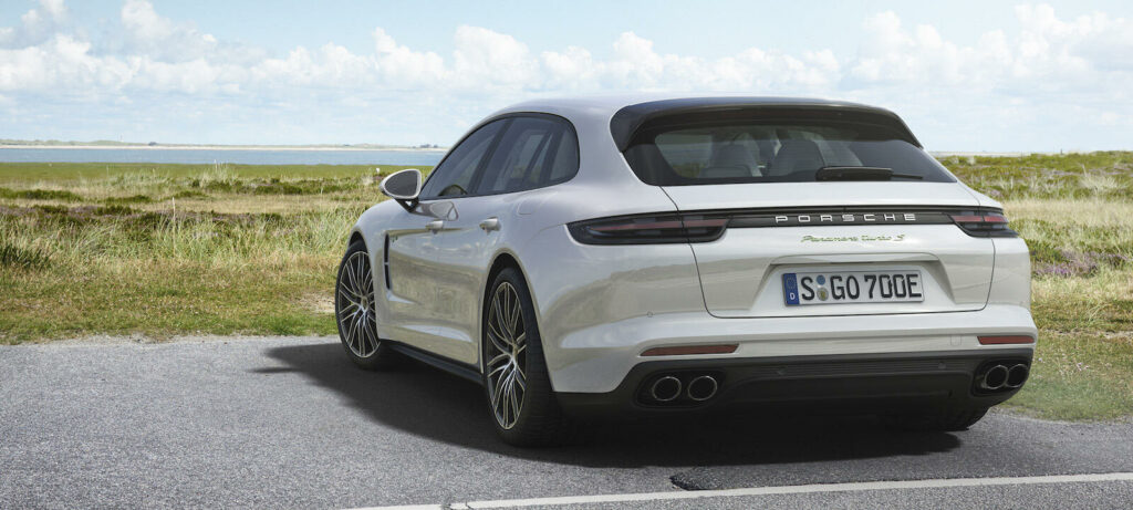 En vit Porsche Macan parkerad vid en vägkant. (AI text)