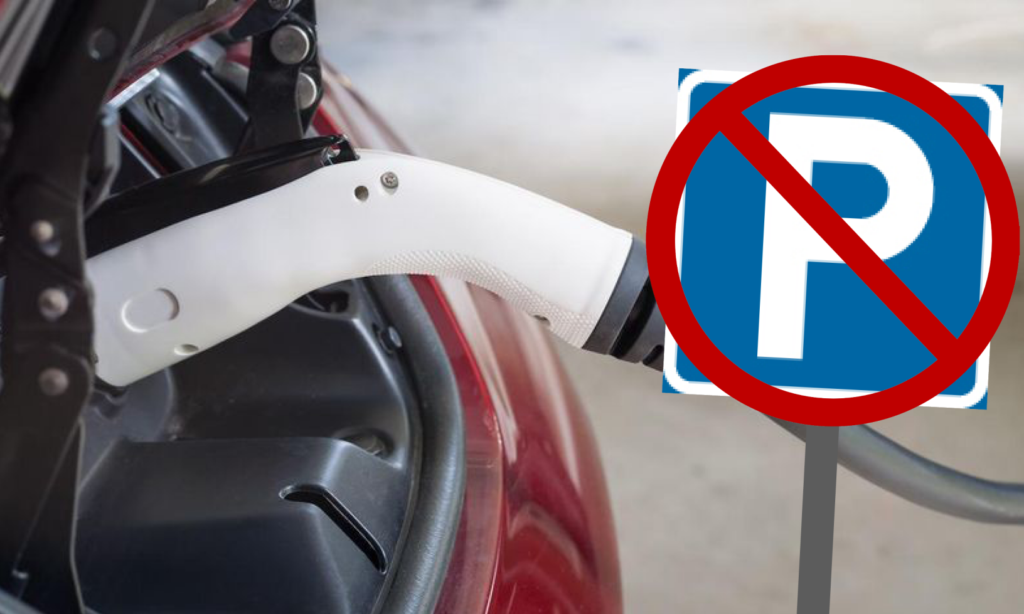 En röd bil är uppkopplad till en elladdare. (AI text)