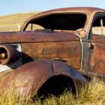 En gammal rostig bil i gräset (AI text)