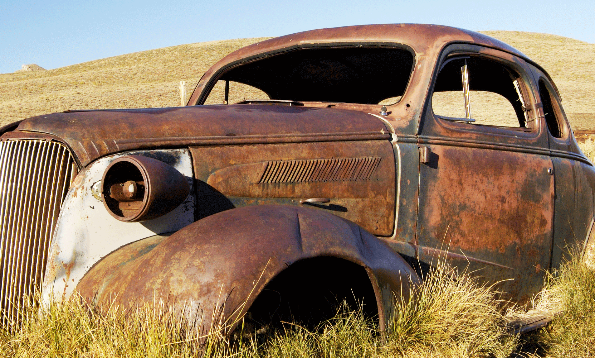 En gammal rostig bil i gräset (AI text)