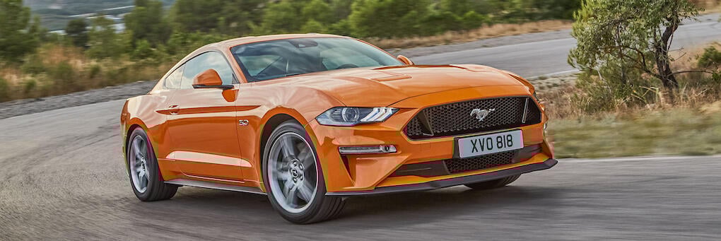 En Ford Mustang GT kör nerför en bergsväg. (AI text)