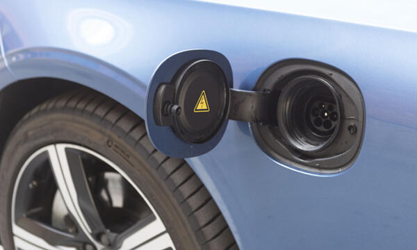 En blå bil är uppkopplad till en elladdare. (AI text)