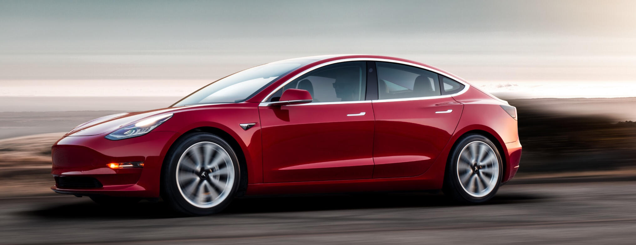 Tesla Model 3 kör på en ökenväg. (AI text)
