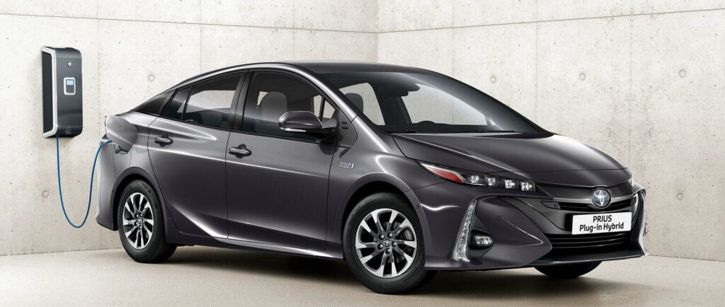 En Toyota Prius ansluts till en laddstation. (AI text)