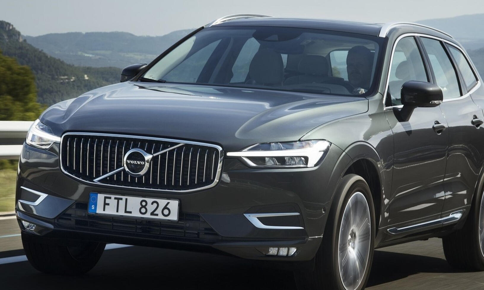 Volvo XC90 SUV kör längs en väg. (AI text)