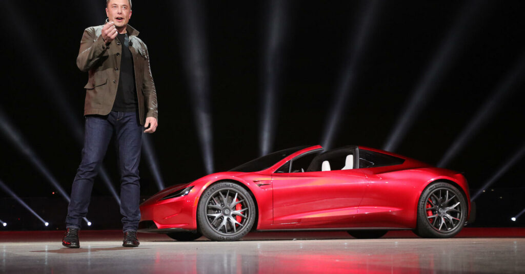 En man står bredvid en röd Tesla Model S. (AI text)