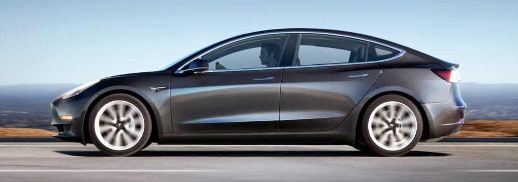 En Tesla Model 3 parkerad vid vägkanten. (AI text)