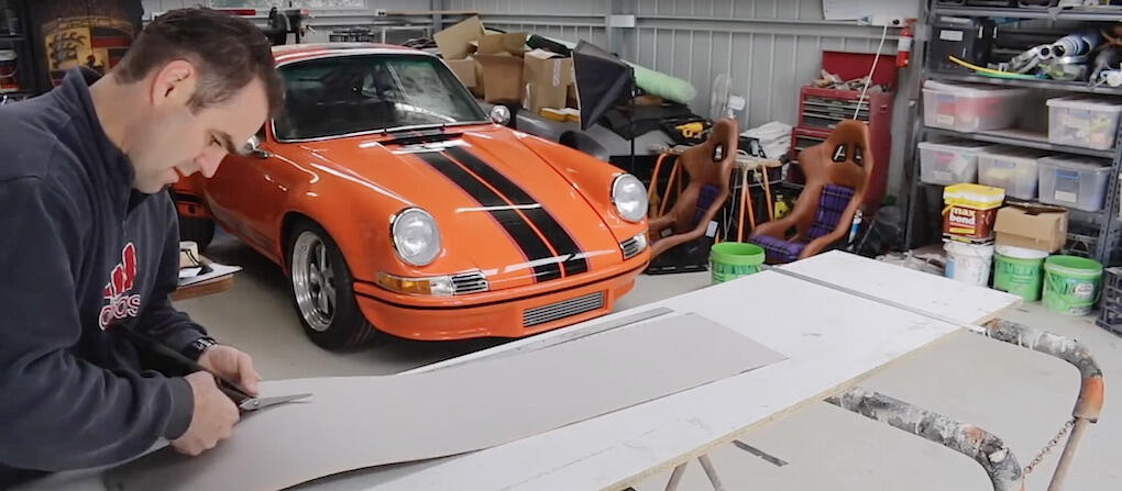 En man arbetar på en bil i en garage. (AI text)