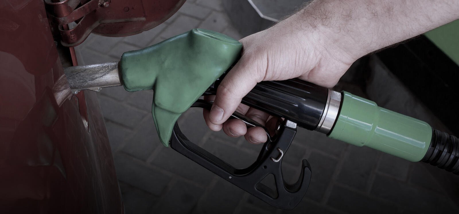 En man tankar bilen med bensin. (AI text)