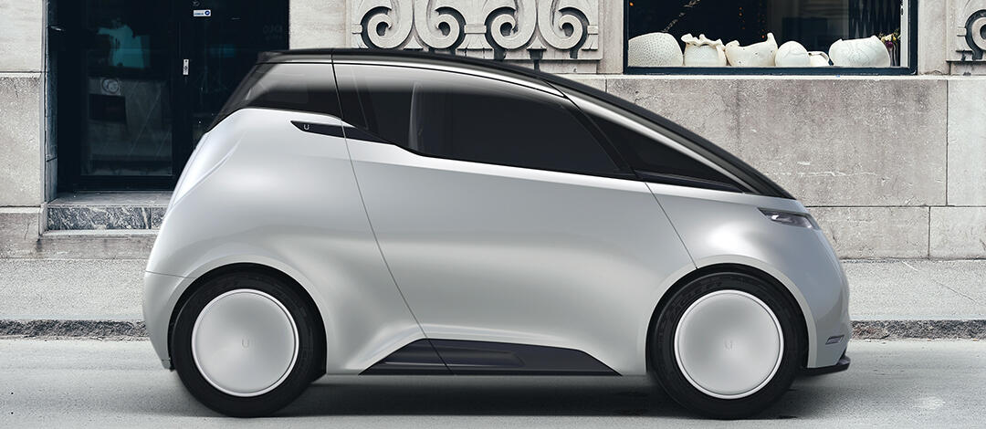 En framtida bil står parkerad framför ett byggnad. (AI text)