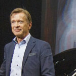 En man står bredvid en bil. (AI text)