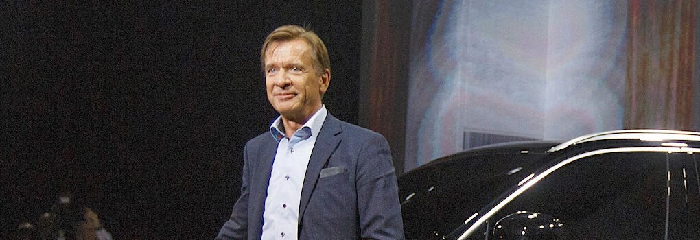 En man står bredvid en bil. (AI text)