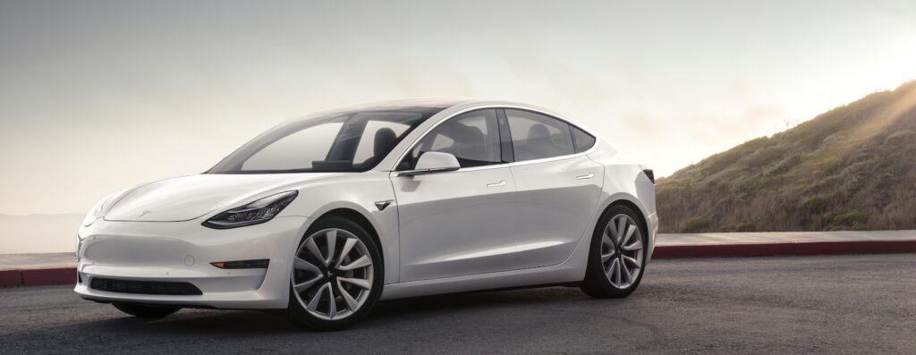 En Tesla Model 3 parkerad på en gata. (AI text)