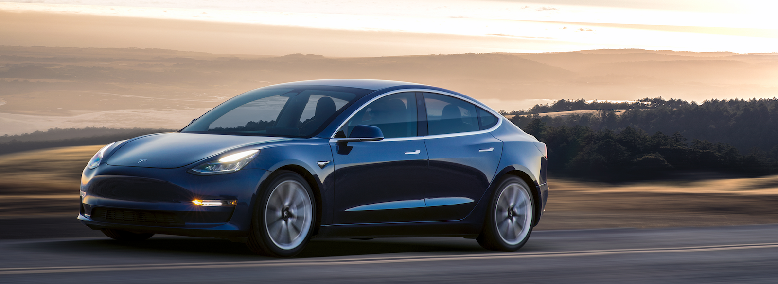 Tesla Model 3 kör på en bergsväg. (AI text)