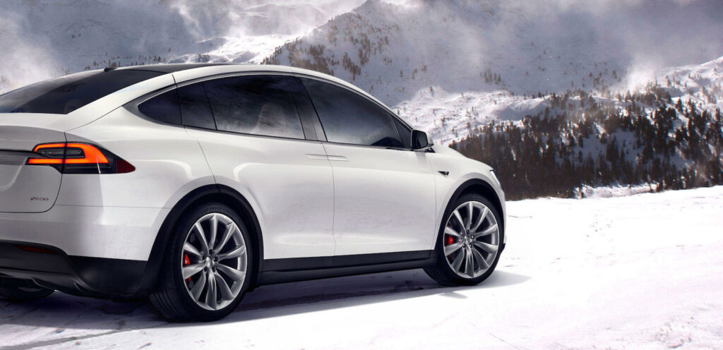 Tesla Model X körande i snön (AI text)