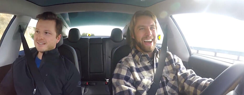 Tesla Model 3 är häftig, det ser man på Andrew Collins (till höger) som fick låna bilen av Mason McLead.