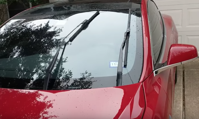 En röd Chevrolet Volt står parkerad framför en garage. (AI text)