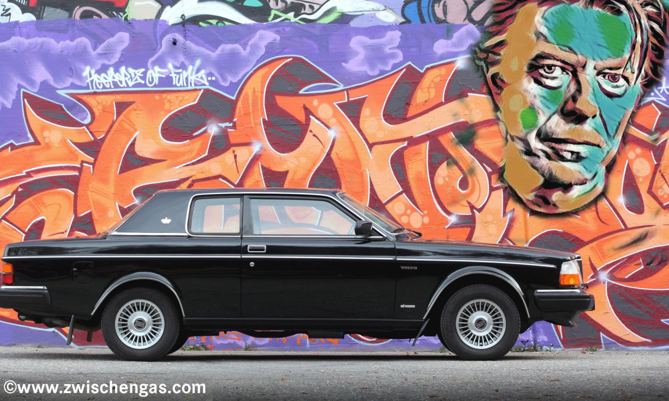 En Volvo S40 parkerad framför en graffitivägg. (AI text)