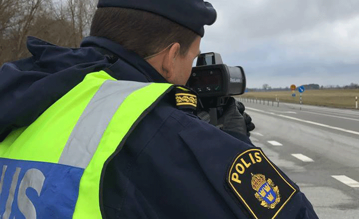 En polisbevakning tar en bild av en bil på vägen. (AI text)