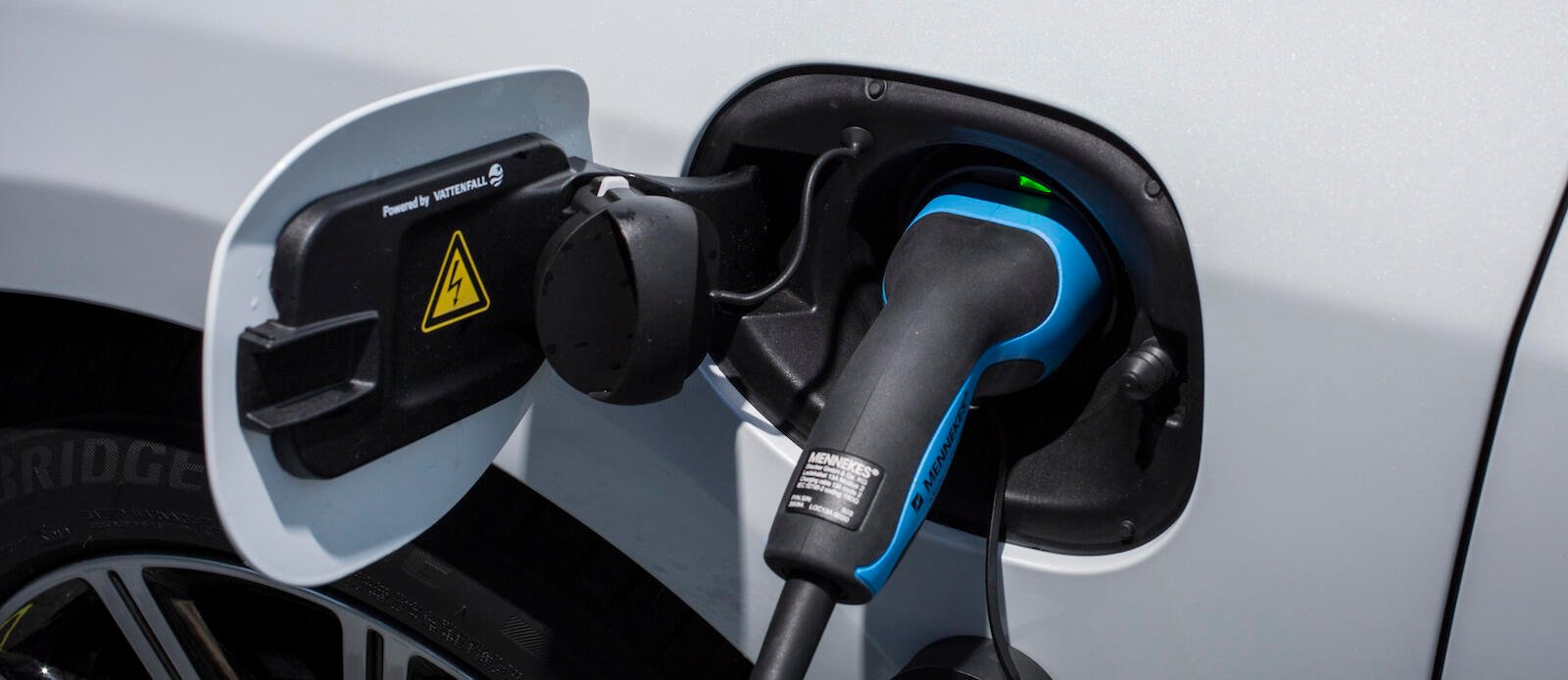 En bil är uppkopplad till en elladdare. (AI text)