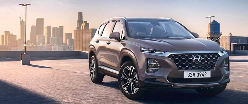 2020 Hyundai Santa Fe står parkerad framför en stadsmotiv. (AI text)
