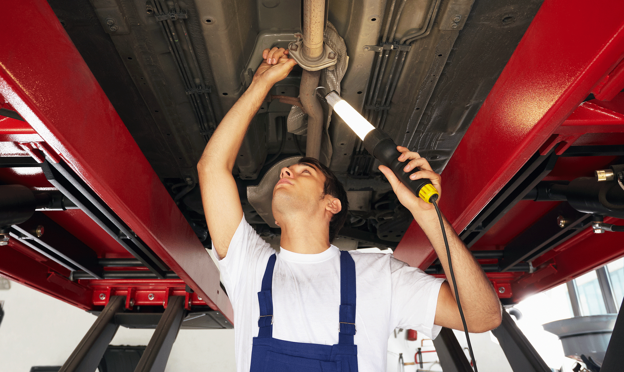 En mekaniker arbetar på en bil i en garage. (AI text)