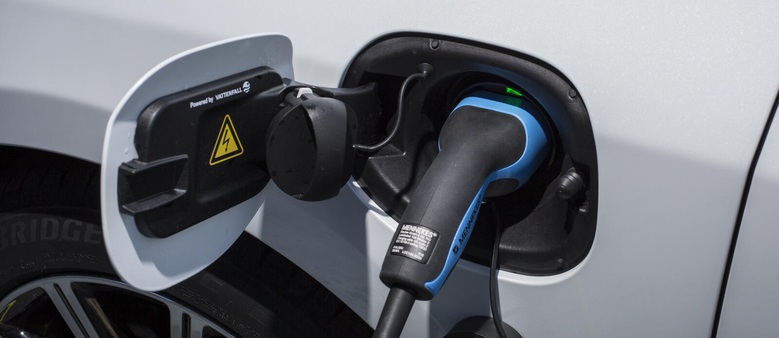 En bil är uppkopplad till en elladdare. (AI text)