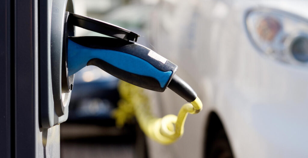 En bil är uppkopplad till en elbilsladdare. (AI text)