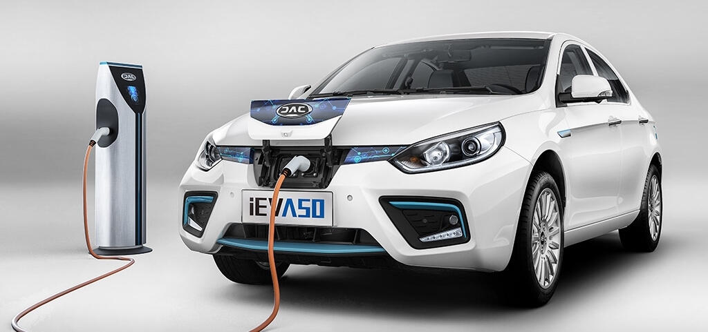 En vit bil är uppkopplad till en elladdare. (AI text)