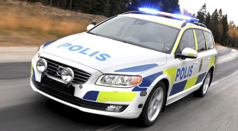 En polisbil kör längs en väg. (AI text)