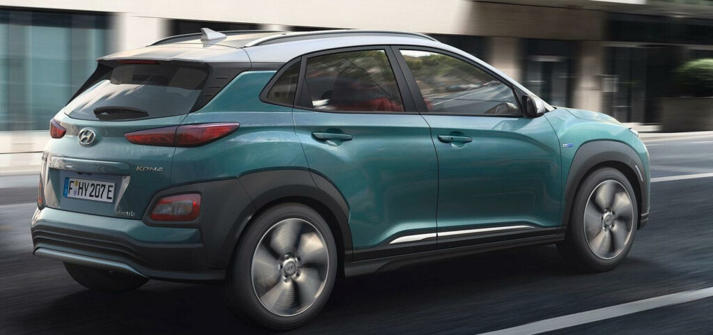 En grön Hyundai Kona kör nerför en stadsgata. (AI text)
