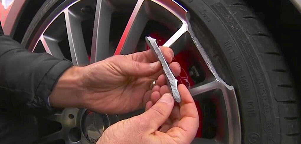 Ett stort stycke av fälgkanten på replikafälgen har gått av efter potthålet. Originalfälgen klarade sig utan skador.