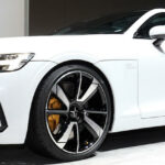 En vit Volvo S90 coupé utställd på Detroit bilmesse. (AI text)
