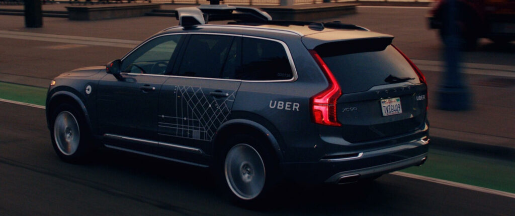 En självkörande Volvo XC90 kör ner en stadsgata. (AI text)