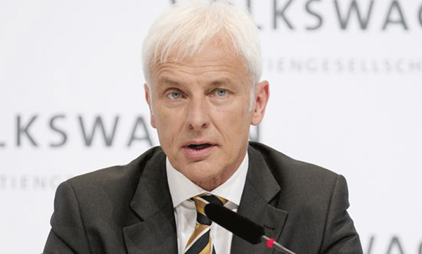 En man i kostym och slips talar vid ett podie. (AI text)