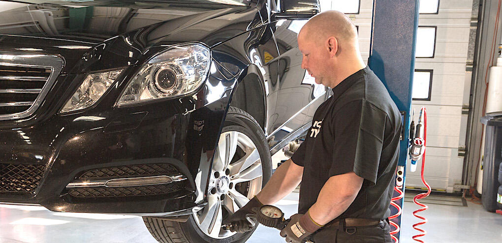 En mekaniker arbetar på en bil. (AI text)