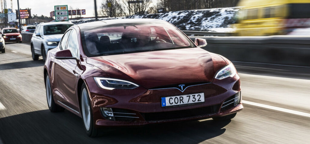 En Tesla Model S kör på en motorväg. (AI text)