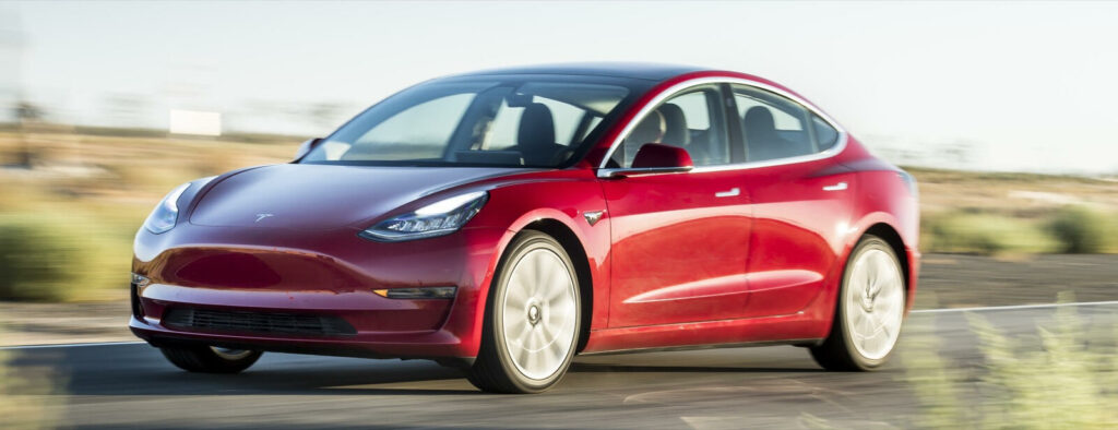 En Tesla Model 3 kör på en landsväg. (AI text)