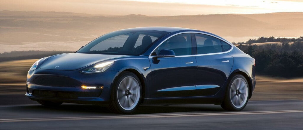 Tesla Model 3 kör på en bergsväg. (AI text)