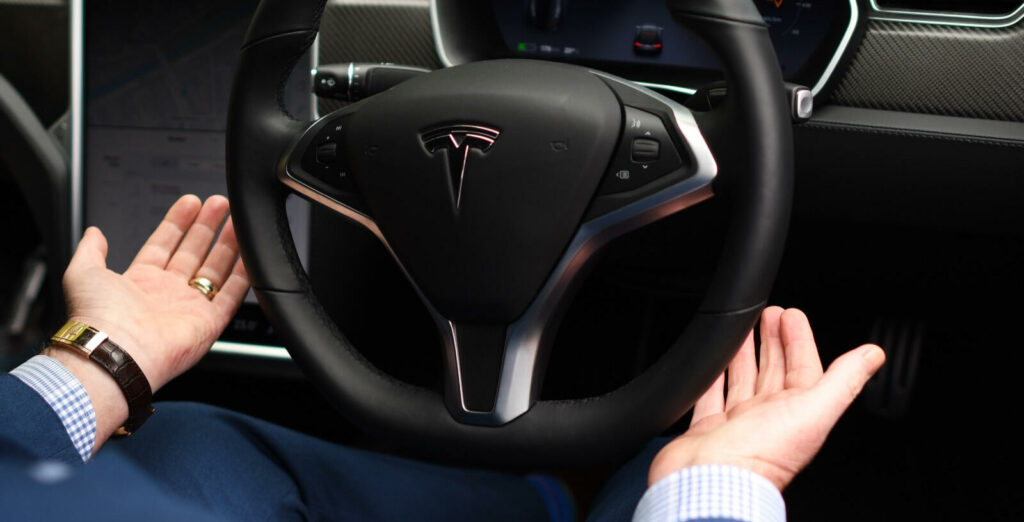 En man sitter i förarsätet i en Tesla Model S. (AI text)