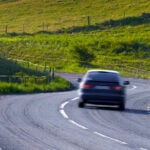 En bil kör nedför en snirklig väg. (AI text)