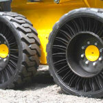 En person kör en traktor med en stor hjul. (AI text)