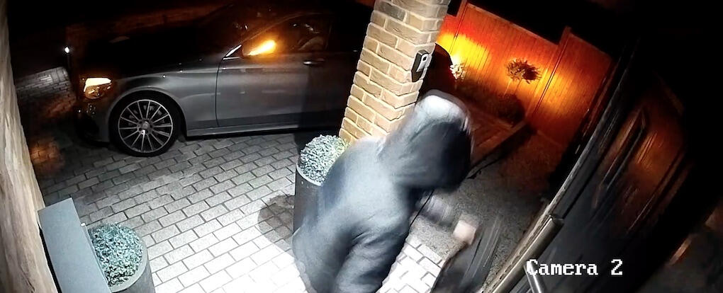 En man i en jacka klämmande går in i ett hus på natten. (AI text)