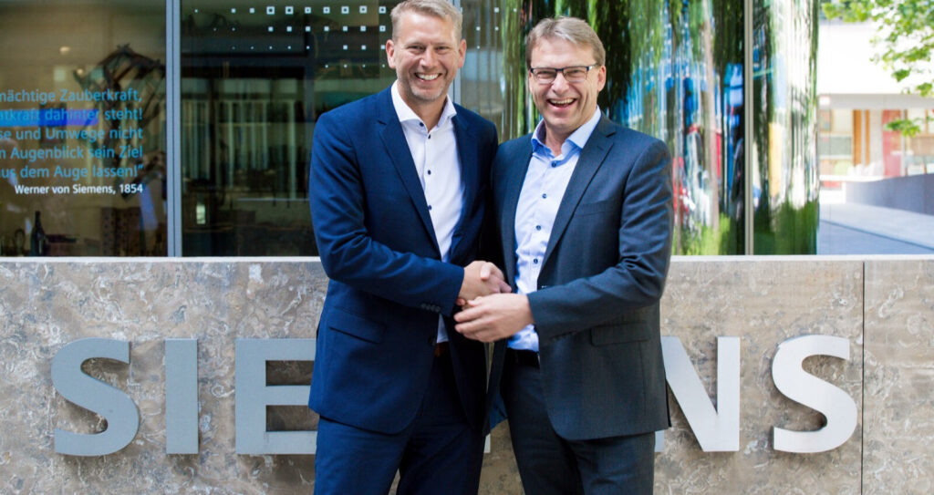 Northvolt har fått till ett avtal med industrijätten Siemens. Peter Carlsson, vd för Northvolt, skakar hand med med Ulf Troedsson, vd för Siemens Nordics.