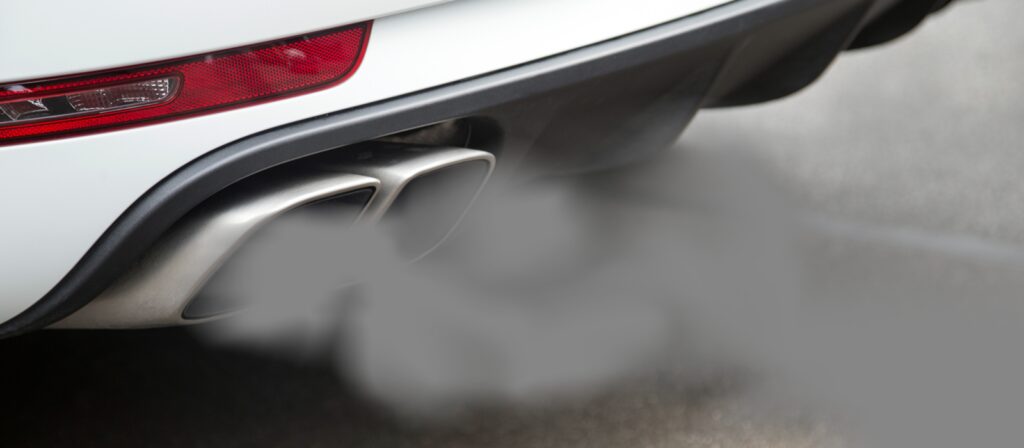 En vit bil med en svart utluftningsrör. (AI text)