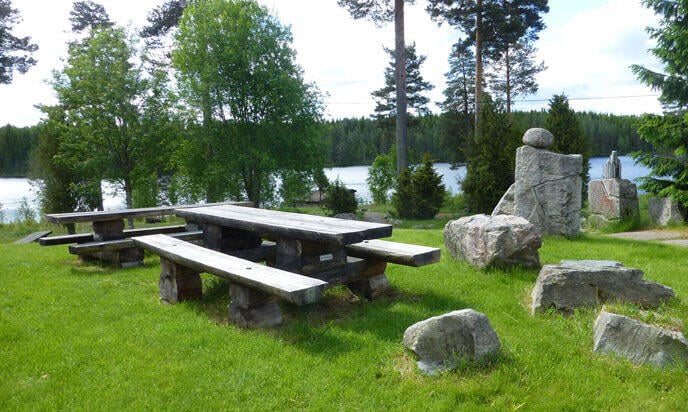 En picknickbord i en gräsmatta (AI text)