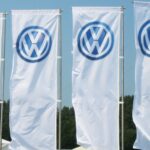 En grupp personer står framför VW-logotypen. (AI text)