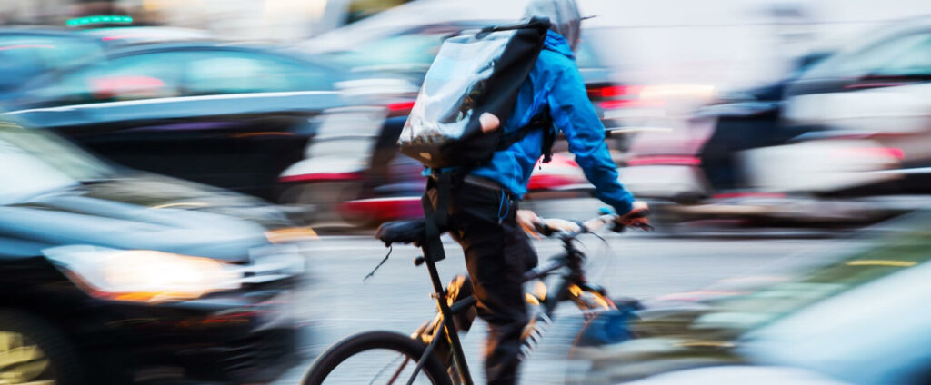 En cyklare cyklar genom en livlig stad. (AI text)