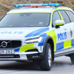En polisbil kör nedför en bergsväg. (AI text)